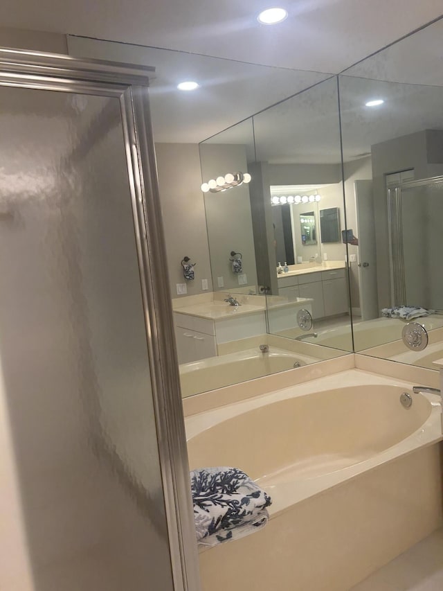 full bathroom featuring recessed lighting, a garden tub, vanity, and a shower stall