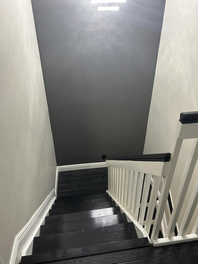 stairway with hardwood / wood-style flooring and baseboards