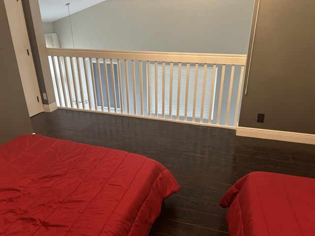 bedroom featuring vaulted ceiling, wood finished floors, and baseboards