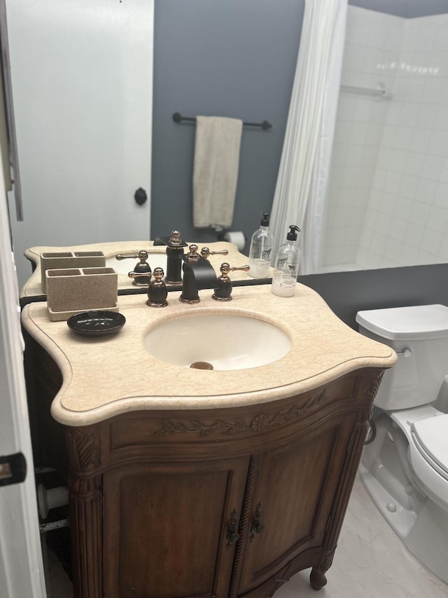 bathroom with toilet, marble finish floor, and vanity