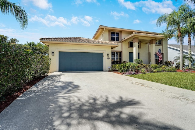 mediterranean / spanish-style house featuring a tile roof, an attached garage, driveway, and stucco siding