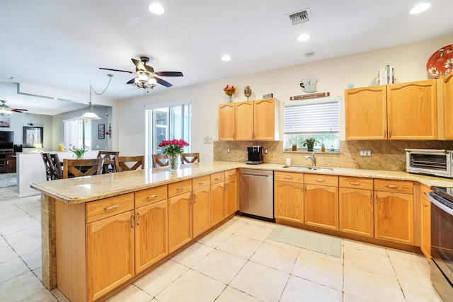 kitchen with a peninsula, ceiling fan, plenty of natural light, and stainless steel appliances