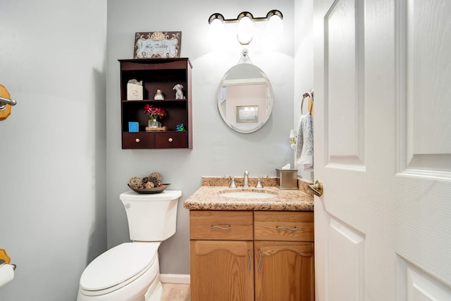 half bathroom featuring vanity and toilet