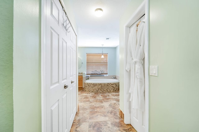 hallway with stone finish floor and visible vents