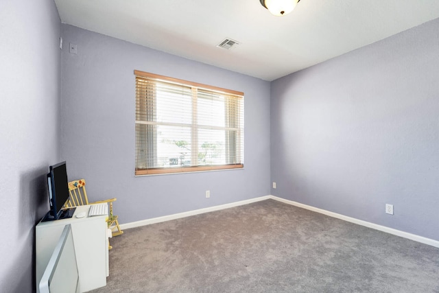 carpeted spare room featuring visible vents and baseboards