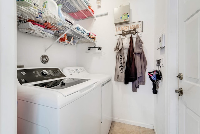 laundry room with laundry area, separate washer and dryer, light tile patterned floors, and baseboards