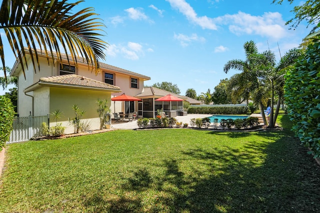 rear view of property featuring a yard, a patio, fence, and stucco siding