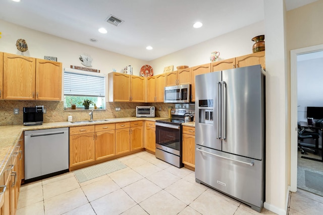 kitchen with visible vents, appliances with stainless steel finishes, decorative backsplash, and a sink