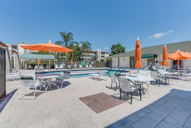 community pool featuring fence and a patio