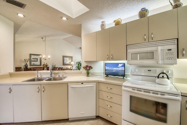 6275 SE Charleston Pl Unit B203, Hobe Sound, FL 33455 - kitchen featuring white appliances, a sink, light countertops, a textured ceiling, and a skylight