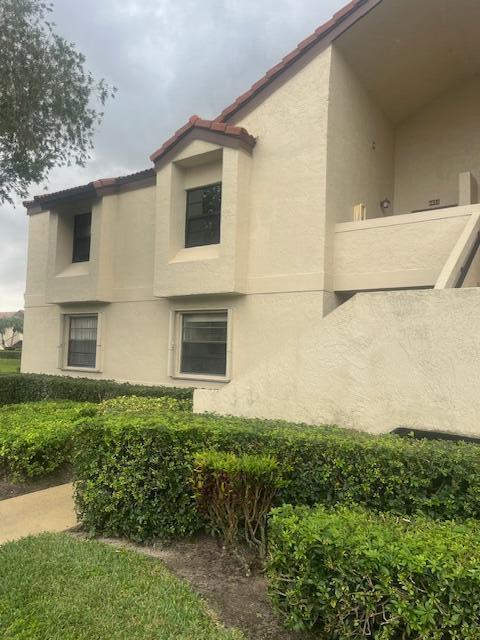 view of property exterior with a tiled roof and stucco siding