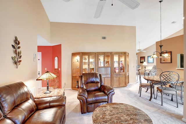 living area with ceiling fan, high vaulted ceiling, visible vents, and light colored carpet