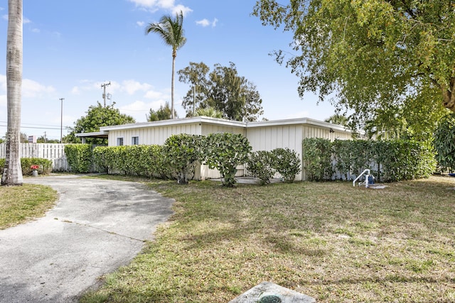 view of front facade featuring a front lawn and fence