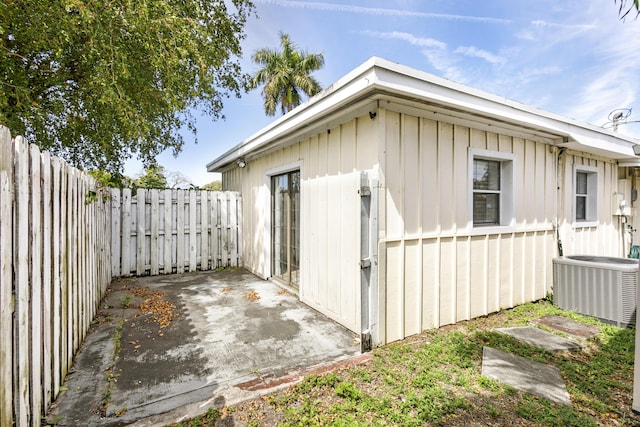 view of outdoor structure with a fenced backyard and central AC