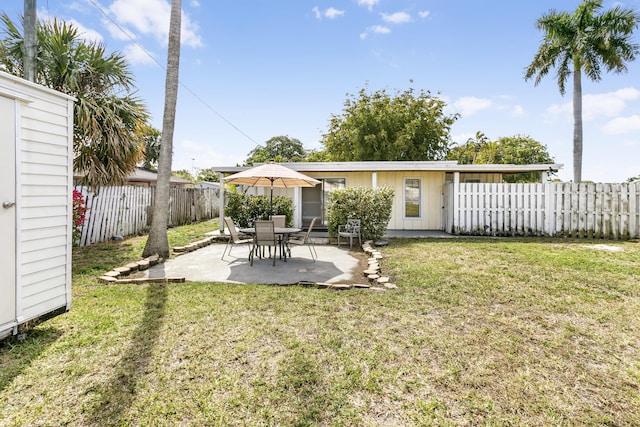 rear view of house with a lawn, a patio area, and a fenced backyard