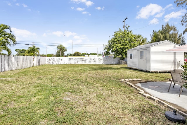 view of yard with a patio area, a fenced backyard, an outdoor structure, and a storage shed