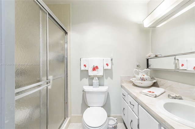 full bathroom with baseboards, toilet, a shower stall, and vanity