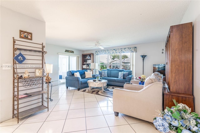 living area with a healthy amount of sunlight, light tile patterned floors, ceiling fan, and a textured ceiling