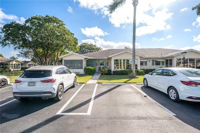 view of front of home featuring uncovered parking and a front lawn