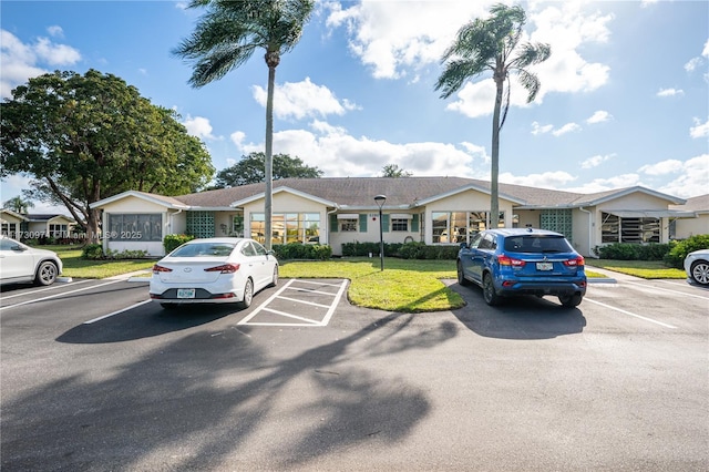 view of front of property with uncovered parking and a front lawn