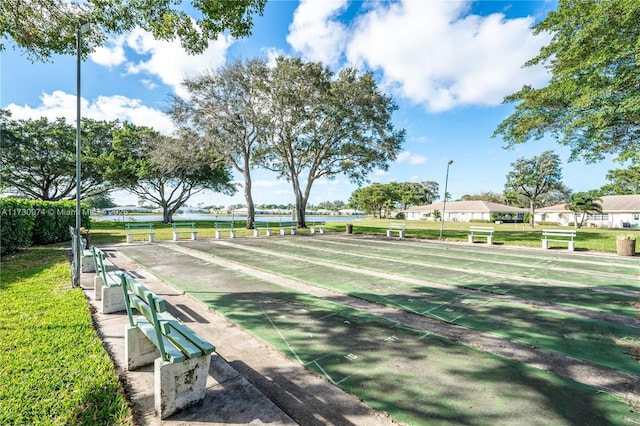 view of home's community with shuffleboard and a lawn