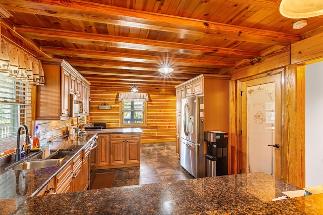 kitchen featuring appliances with stainless steel finishes, wood ceiling, a sink, and wooden walls