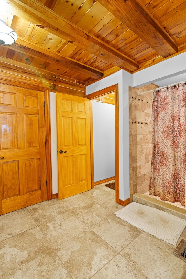 interior space with beamed ceiling, wooden ceiling, visible vents, and baseboards