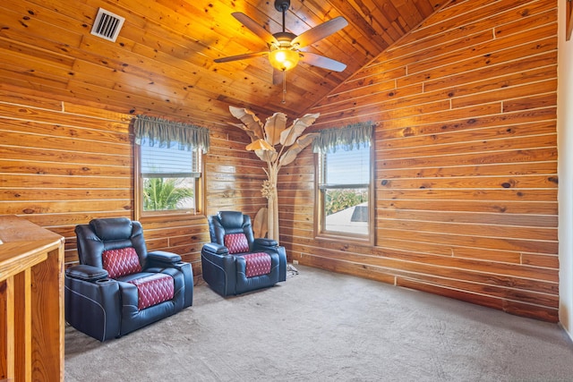 living area featuring lofted ceiling, wooden walls, carpet floors, wood ceiling, and visible vents