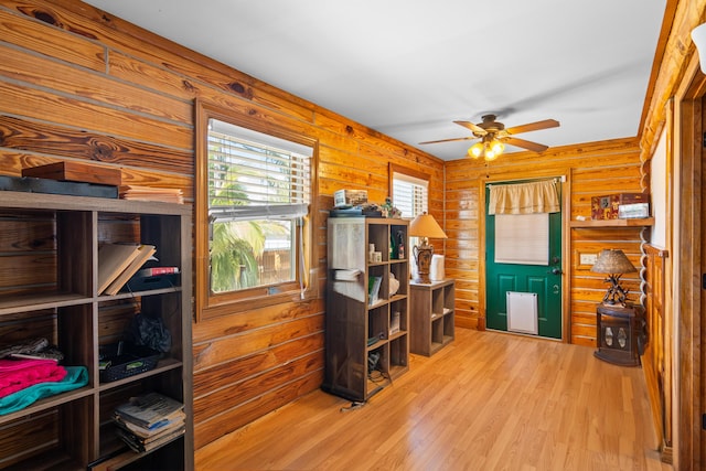 office with ceiling fan, wood finished floors, and log walls