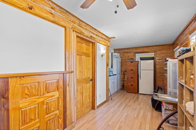 kitchen featuring freestanding refrigerator, ceiling fan, log walls, and light wood finished floors