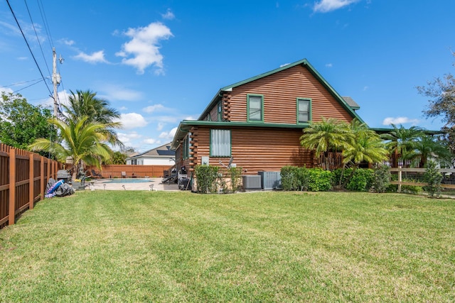 rear view of house with a fenced in pool, a lawn, log exterior, a fenced backyard, and central air condition unit