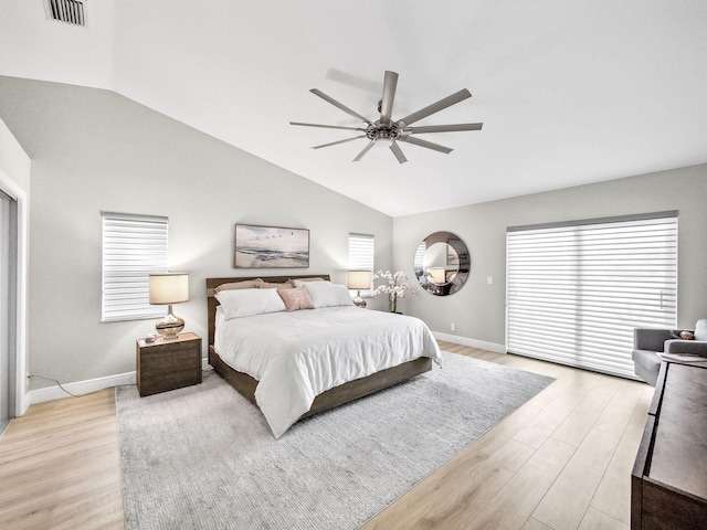 bedroom featuring light wood-type flooring, visible vents, lofted ceiling, and baseboards