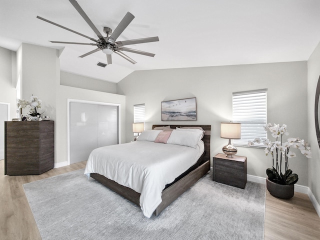 bedroom featuring visible vents, lofted ceiling, baseboards, and light wood-style flooring