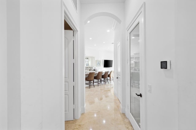 corridor with arched walkways and recessed lighting