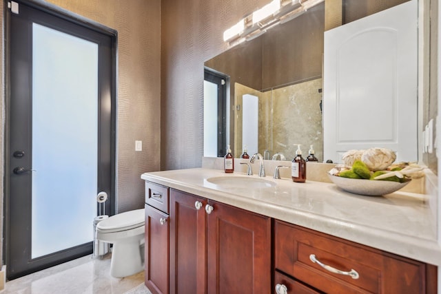 bathroom with toilet, vanity, and tile patterned flooring