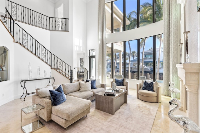 living room with stairs, a high ceiling, a high end fireplace, and a wealth of natural light