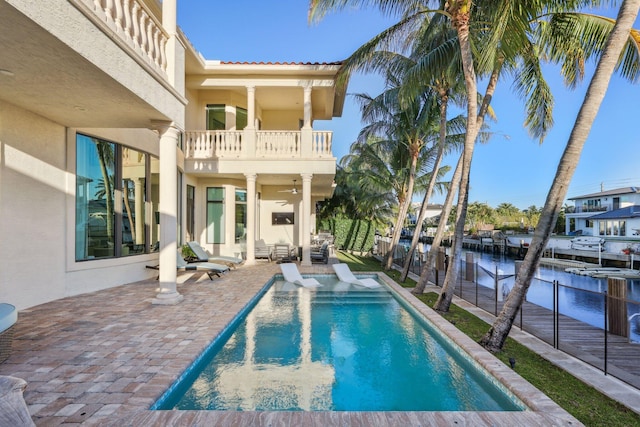 view of swimming pool featuring a fenced in pool, a water view, fence, and a patio area