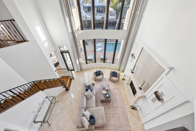 living area featuring a towering ceiling and stairs