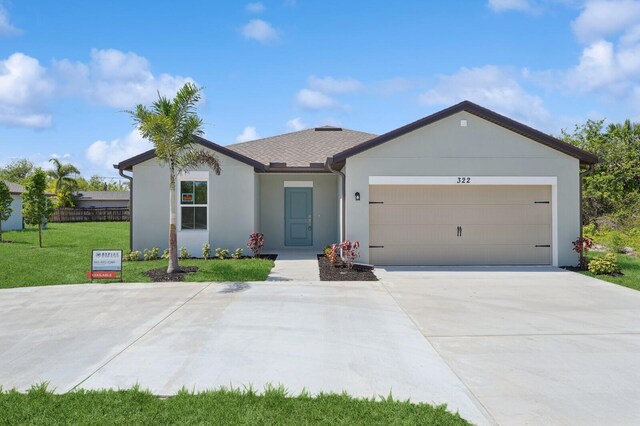 322 Becker Rd Unit 13, Port Saint Lucie, FL 34953 - ranch-style home with a front lawn, an attached garage, stucco siding, and driveway