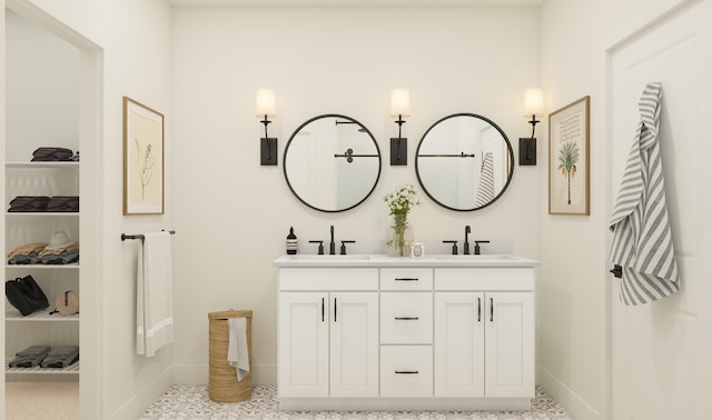 full bathroom featuring double vanity, baseboards, and a sink