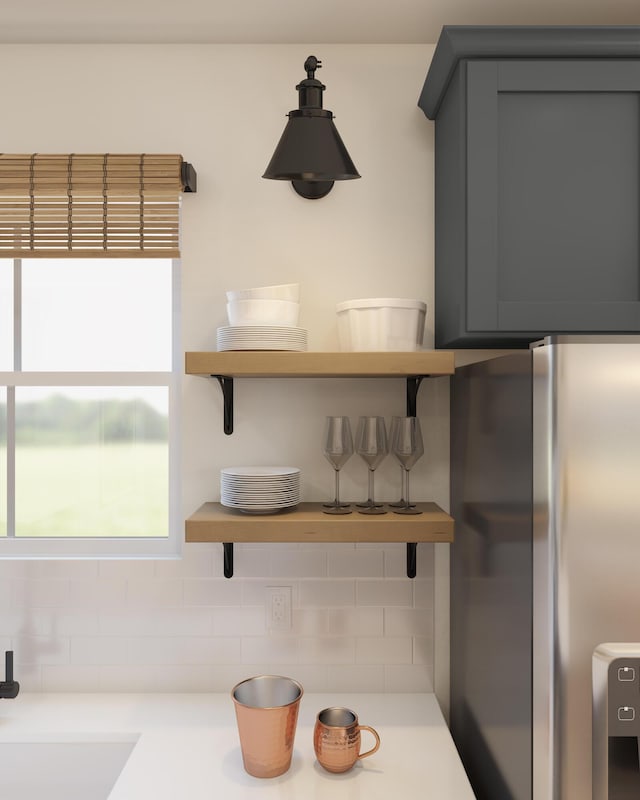 room details with open shelves, light countertops, freestanding refrigerator, and gray cabinetry