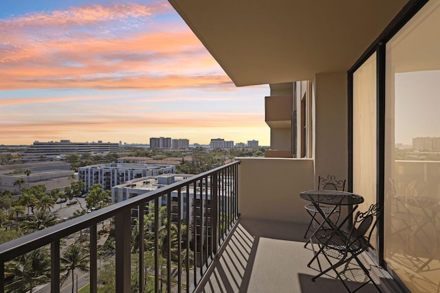 balcony at dusk featuring a view of city