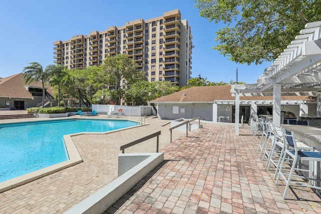 pool with a patio, fence, and a pergola