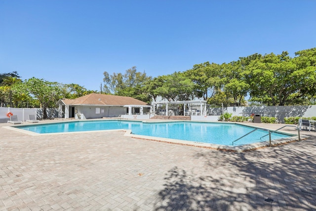 community pool featuring a patio area, fence, and a pergola