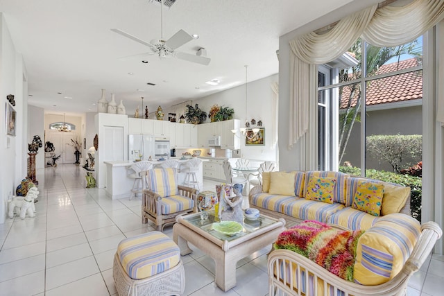 living room featuring light tile patterned floors and ceiling fan with notable chandelier