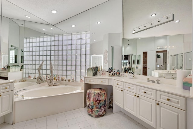 bathroom with a garden tub, tile patterned flooring, vanity, tile walls, and recessed lighting