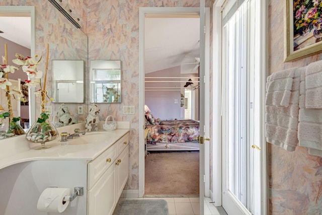 ensuite bathroom featuring ceiling fan, vanity, ensuite bath, tile patterned flooring, and wallpapered walls