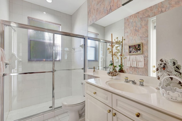 bathroom featuring a shower stall, toilet, and vanity