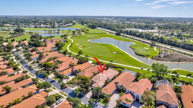 aerial view with golf course view, a water view, and a residential view