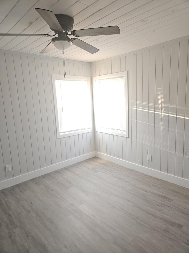 spare room featuring ceiling fan, baseboards, and wood finished floors